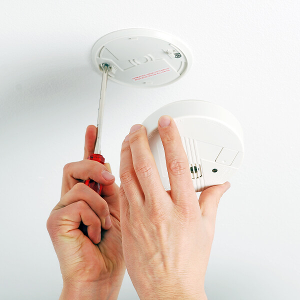 Ein Rauchwarnmelder wird repariert